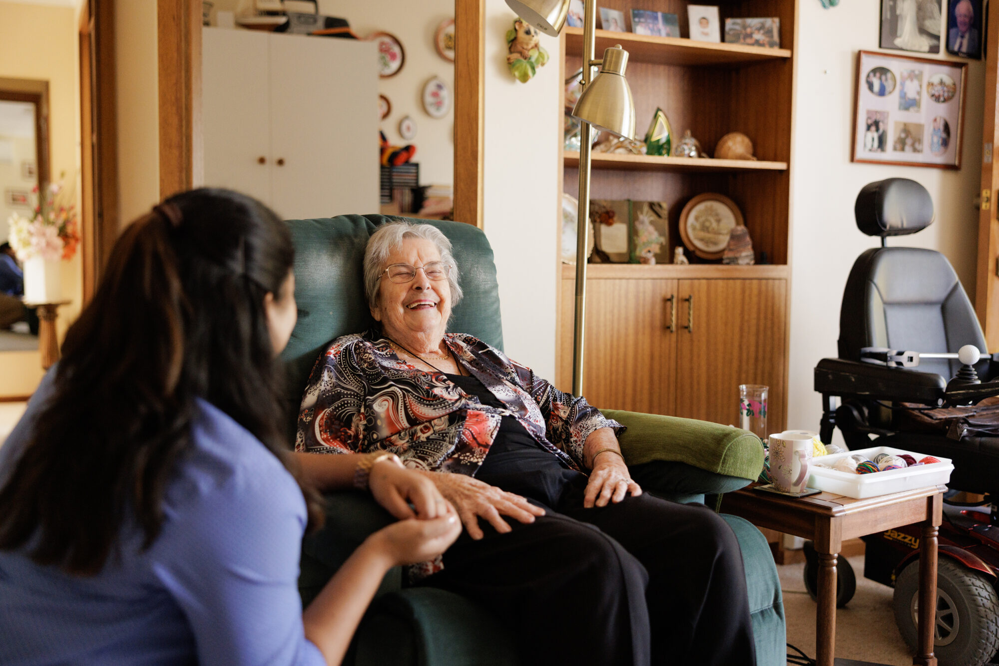 A care assistant laughing with a resident.