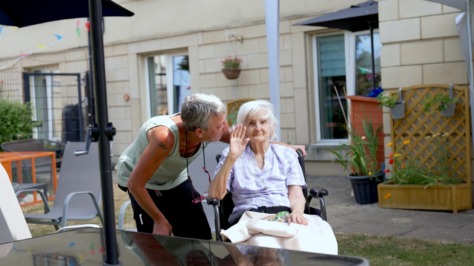 A carer chatting with a resident in the garden.