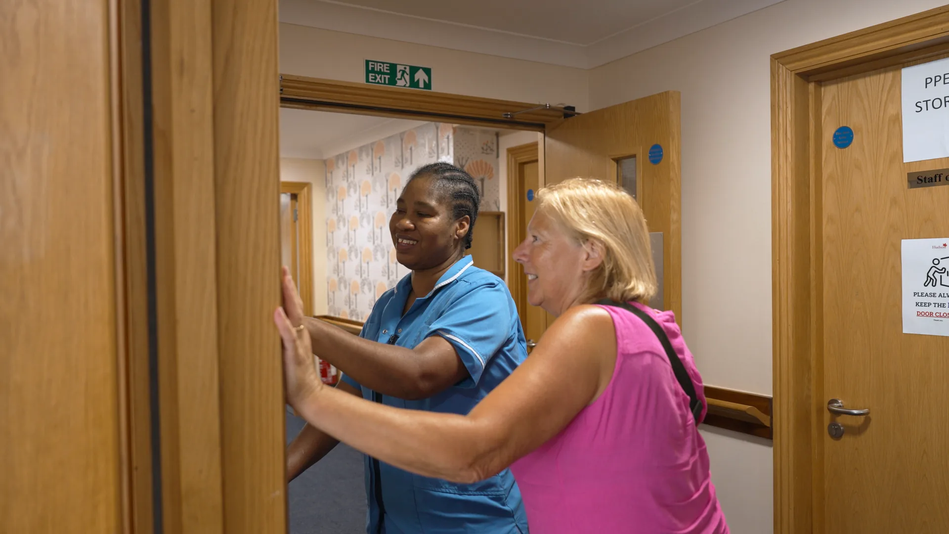 A carer welcoming a visitor at the door.