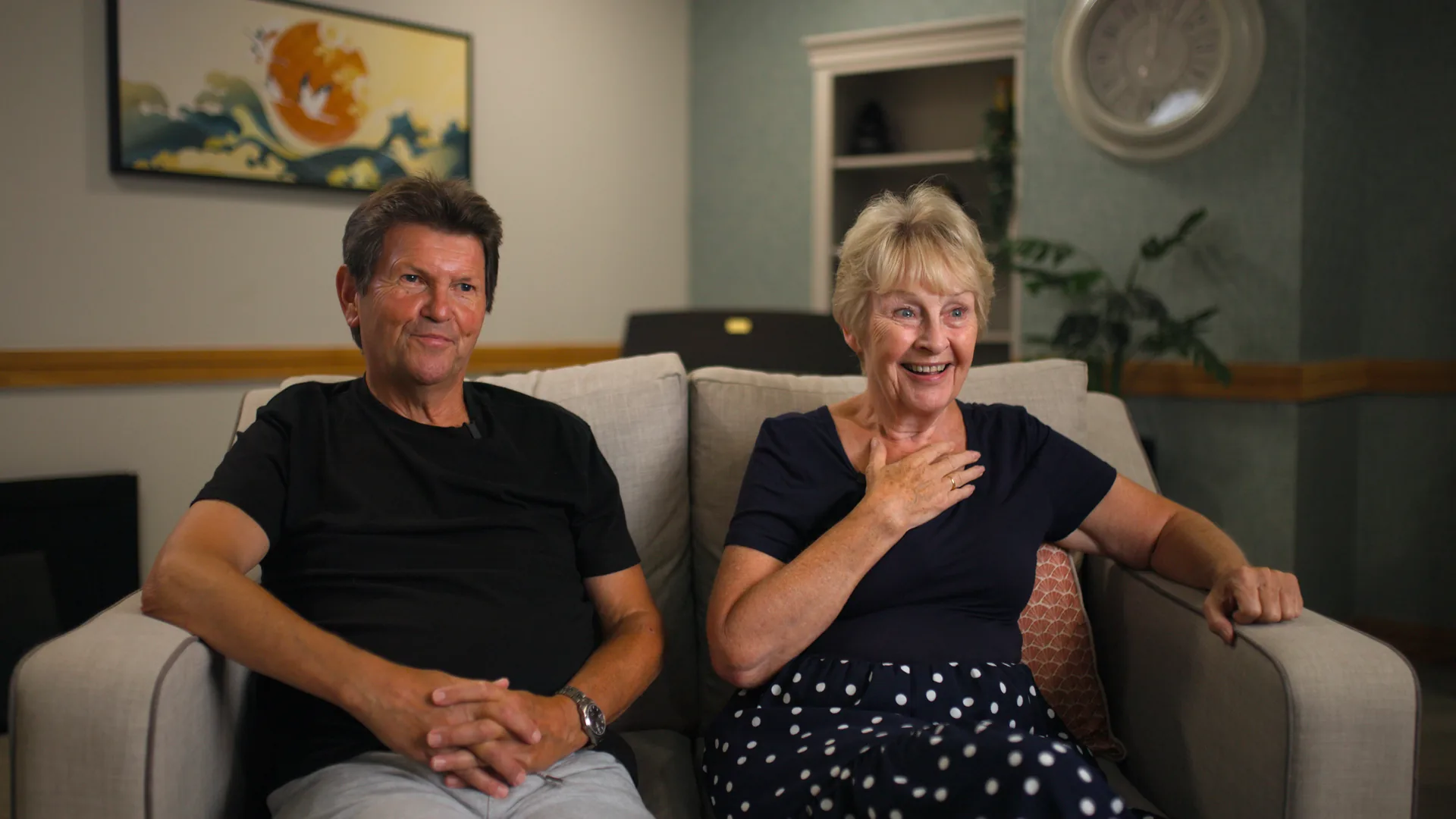 A couple sharing their family's story in the lounge.