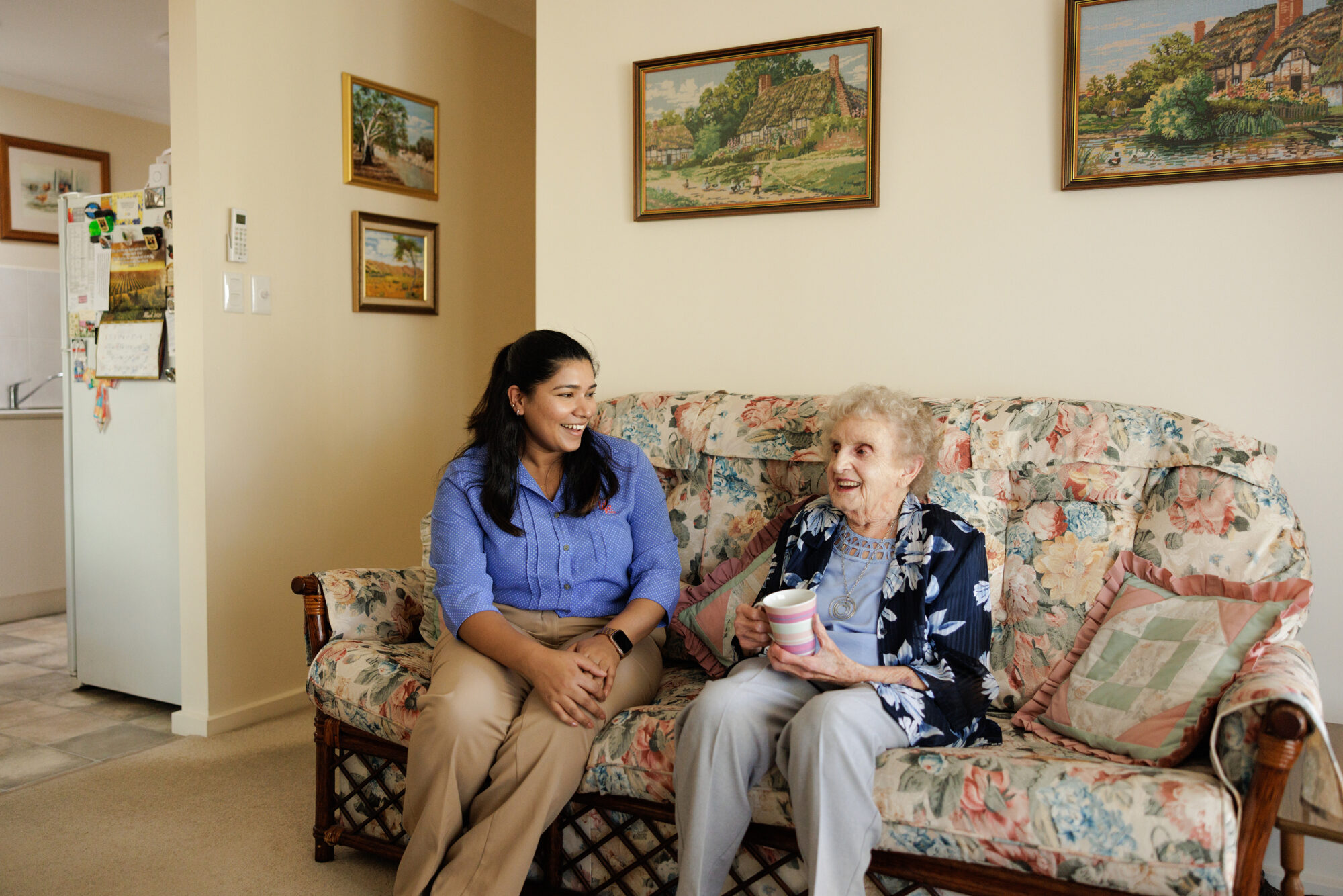 A manager sitting and chatting warmly with a resident at home.
