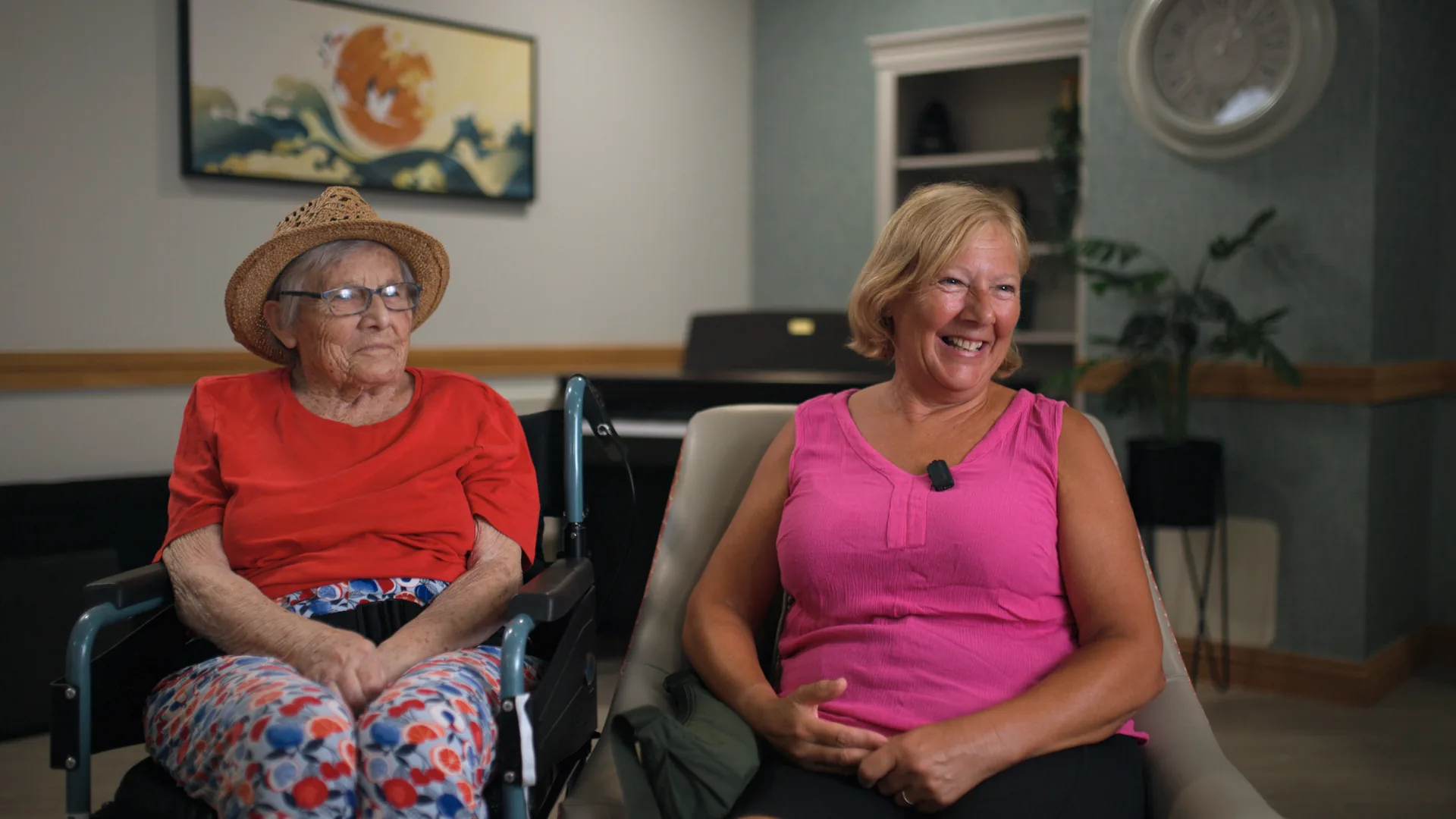 A resident and her daughter smiling together in the lounge.